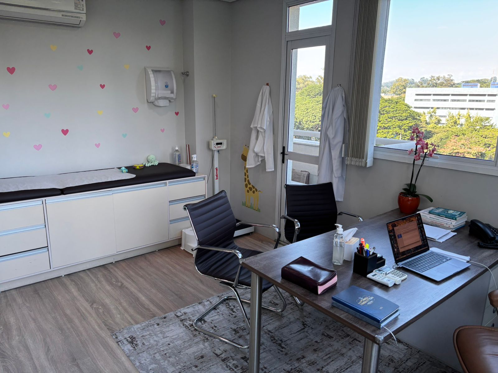 Sala de puericultura com maca e balança de bebê